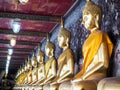 Close up to golden seated Buddha images at corridor.